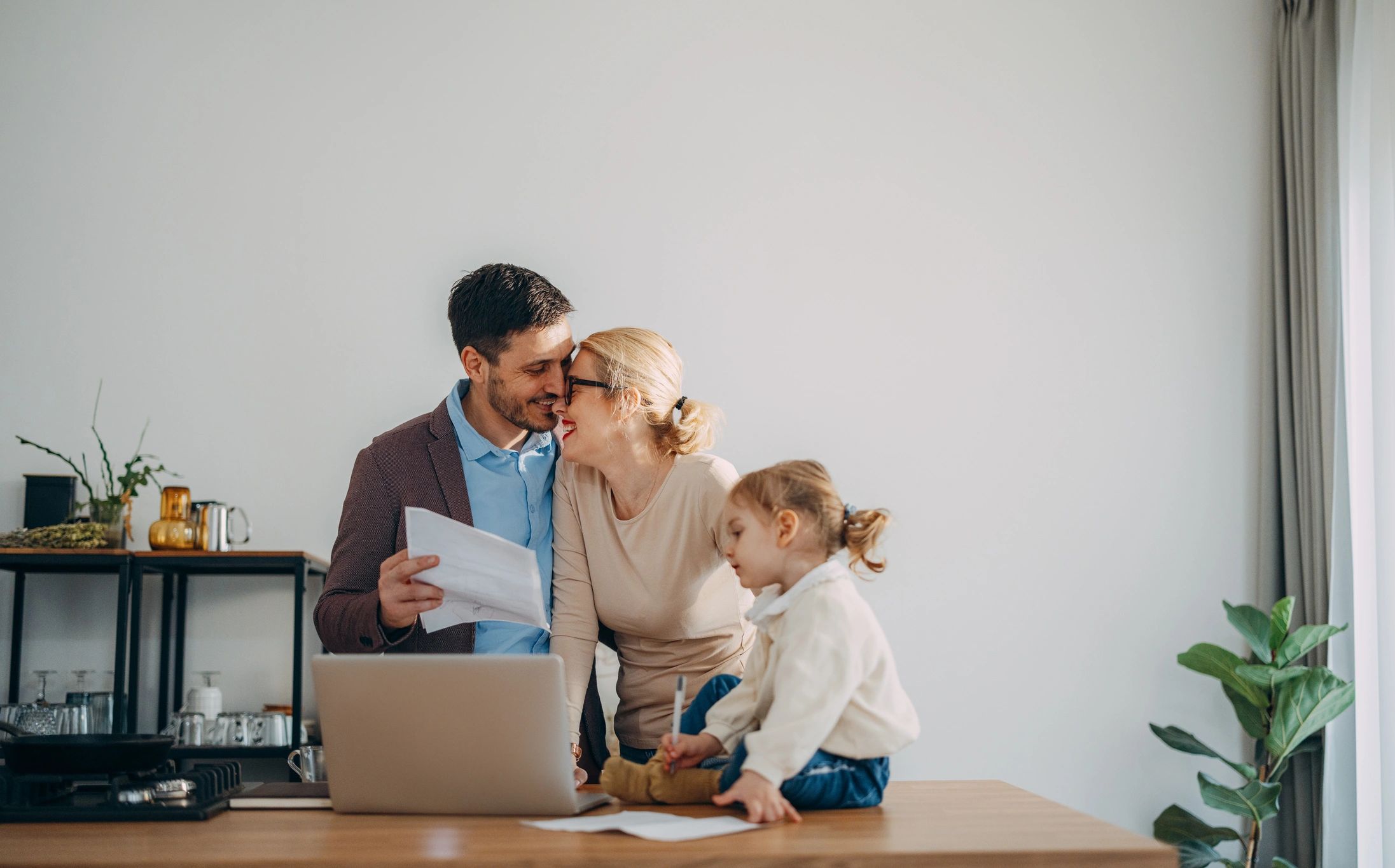 Happy couple with a child reviewing finances together at home