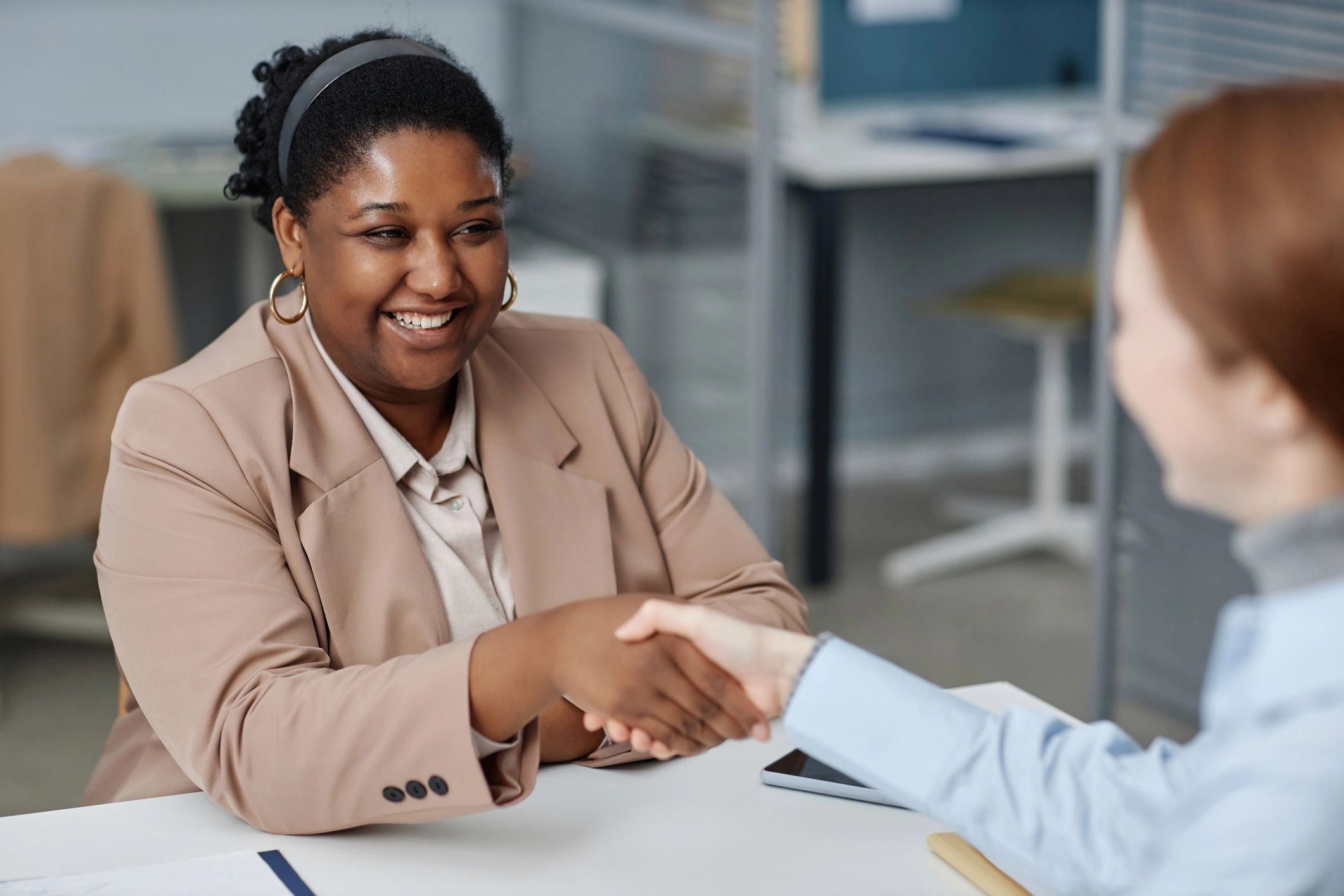 Professional advisor greeting a client at a desk